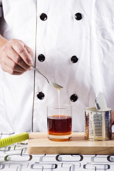 Pouring condensed milk on a cup of tea