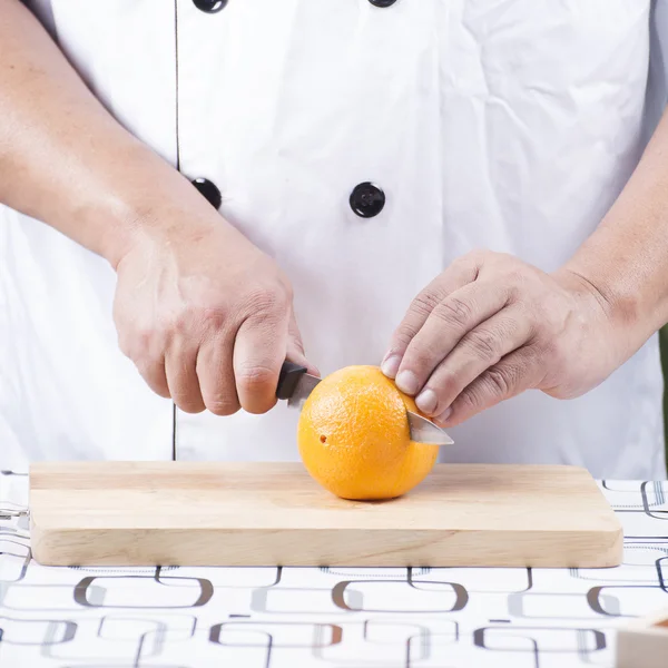 Chef cutting orange