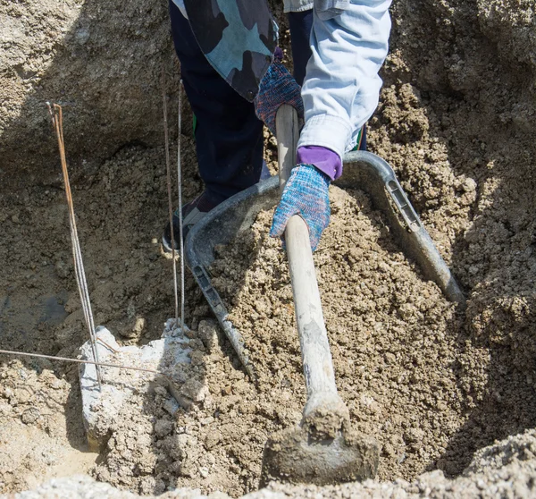 Worker  digging hole with a hoe  at construction site