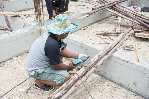 Man use eectric drill to drill the concrete beam