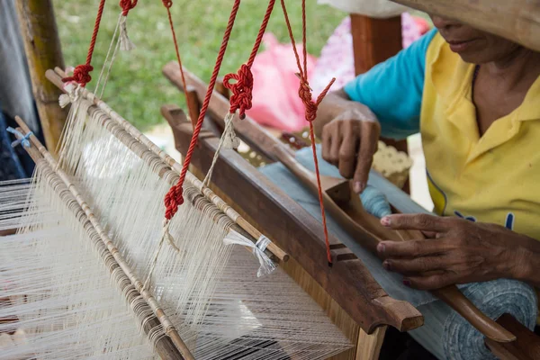 Woman weaving silk in traditional way at manual loom. Thailand