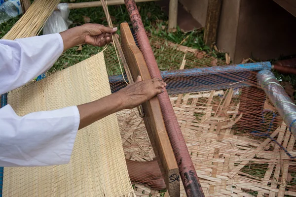 Woman weaving silk in traditional way at manual loom. Thailand