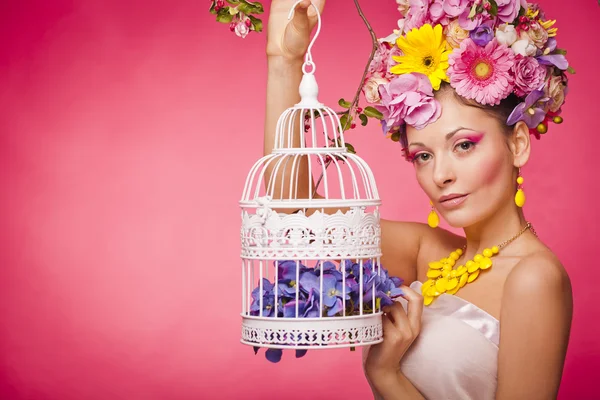 Healthy girl with a birdcage and flowers