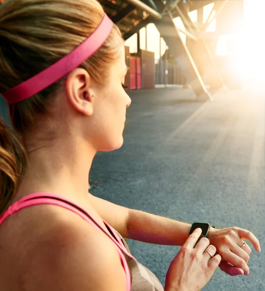 Woman programming her smartwatch before going jogging to track performance