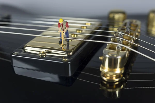 Miniature Worker On Top Of Electric Guitar Pickup