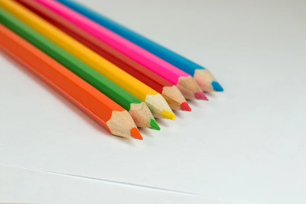 Colored pencils to draw lying on a blank sheet of paper