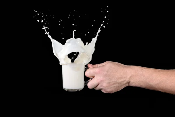Hand holding a cup of milk