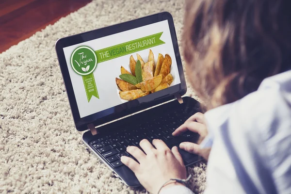 Woman visiting a vegan restaurant website at home.