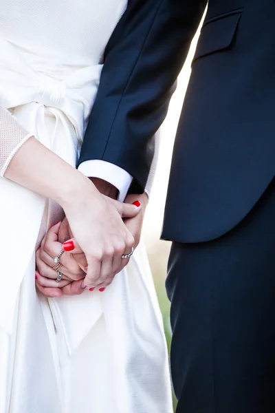 Wedding couple holding hands close up.