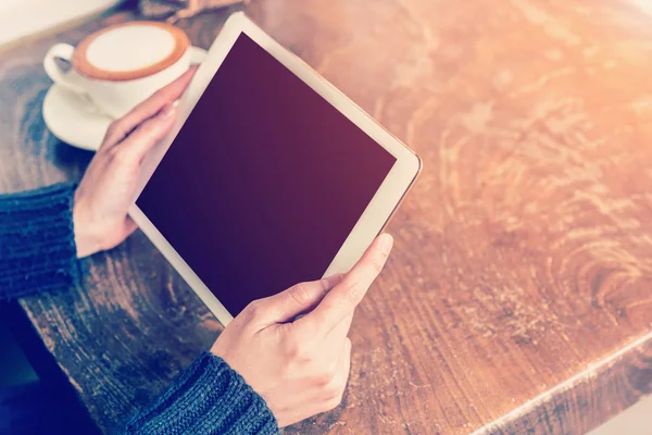 Asian woman hand holding tablet and using tablet in coffee shop