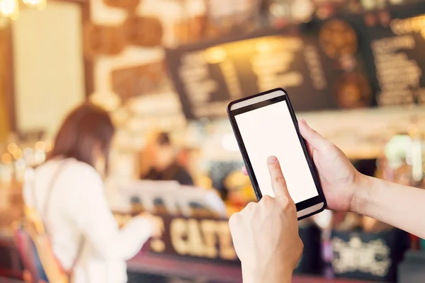 Hand using smartphone and Blurred people in coffee shop with vin