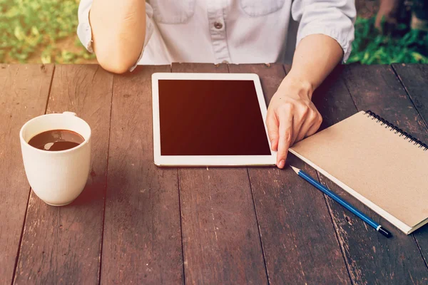 Asian woman using tablet on table and coffee in garden with vint