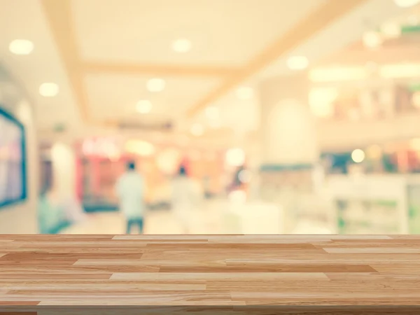 Wood table and shopping mall Blurred background with space for p