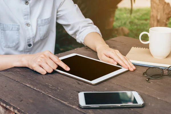 Asian woman using tablet in garden at coffee shop with vintage t