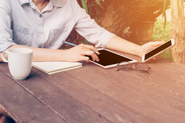 Woman using phone on table wood in garden at coffee shop with vi