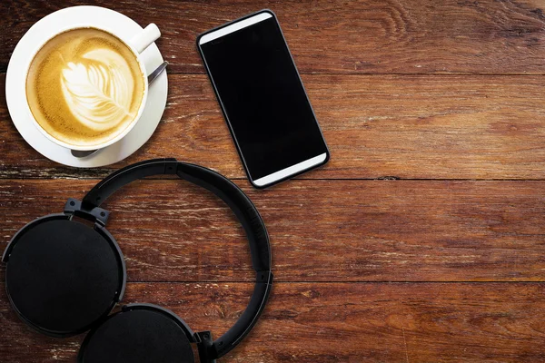 Headphone coffee and phone on wood background and texture with s