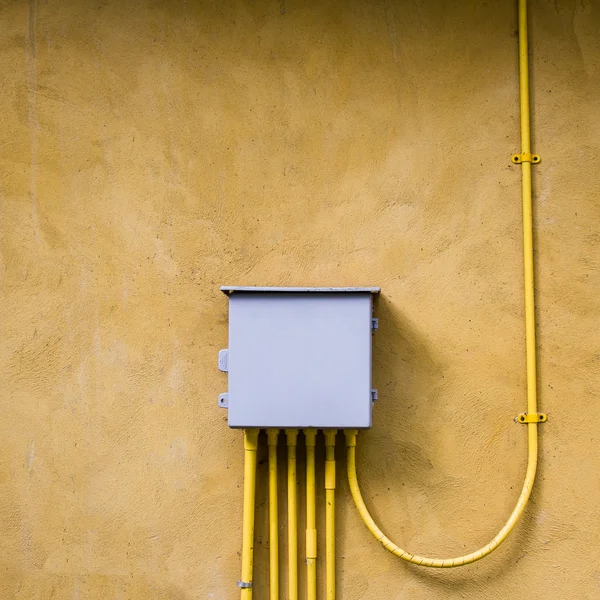 Control electrical box on yellow wall background.