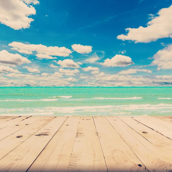 Beach sea and blue sky clouds with wood table, vintage tone.