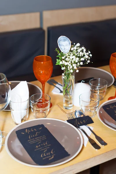 Decorated table ready for dinner. Beautifully decorated table set with flowers, candles, plates and serviettes for wedding or another event in the restaurant.