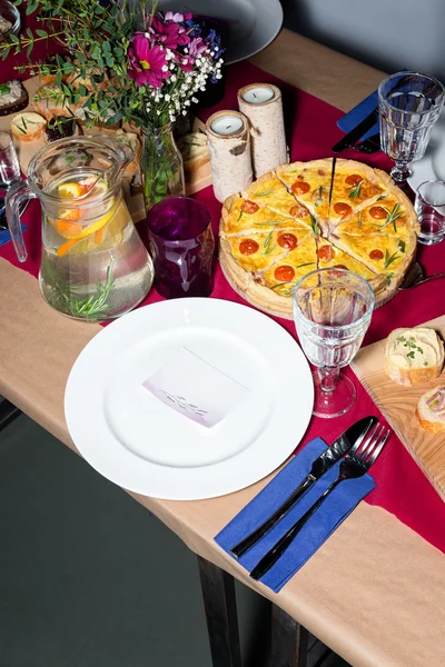 Decorated table ready for dinner. Beautifully decorated table set with flowers, candles, plates and serviettes for wedding or another event in the restaurant.