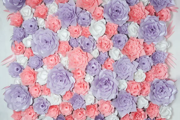 Colorful paper flowers background. Floral backdrop with handmade roses for wedding day or birthday.