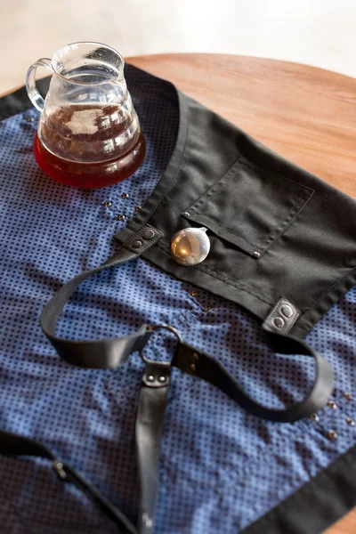 Barista apron on the table in cafe waiting for its owner. Product photography. Coffee preparation service concept.
