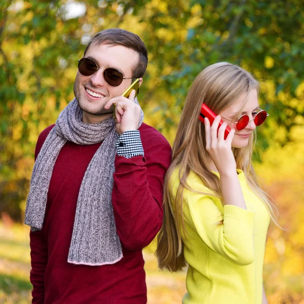 Young couple using a mobile phones. Young couple talking themselves by mobile phone.