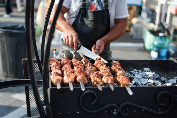 Man cooking, only hands, he is cutting meat or steak for a dish. Delicious grill. Barbecue weekend. Selective focus.