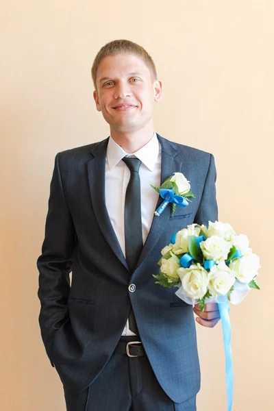 Groom at wedding Day with bouquet for his bride