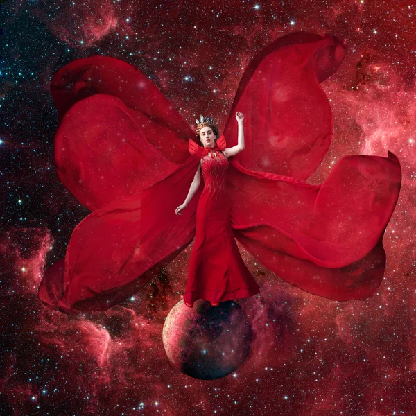 Red space queen. Beautiful woman in a fluttering dress standing and balancing on the planet in outer space. Fantastic art work. Elements of this image furnished by NASA.