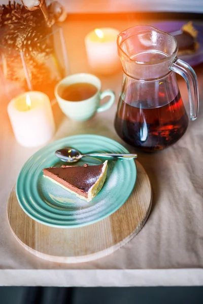 Piece of delicious chocolate mousse cake on colorful plate on wooden table background. Table setting for tea party. Selective focus.