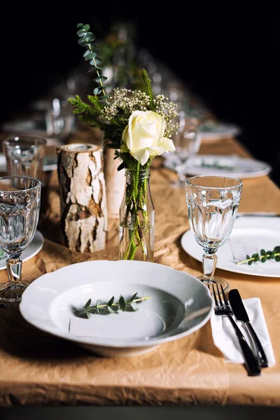 Decorated table ready for dinner. Beautifully decorated table set with flowers, candles, plates and serviettes for wedding or another event in the restaurant.