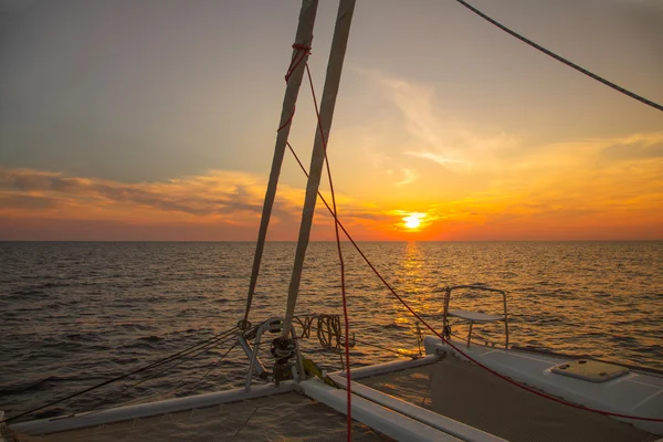 Sailing holidays: sunset with horizon while cruising with a sail