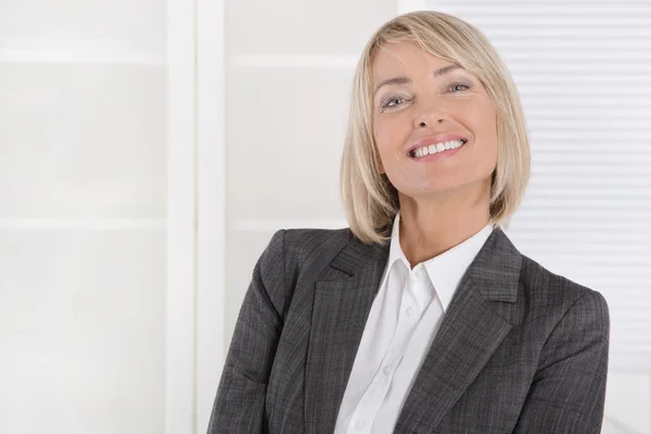 Attractive smiling middle aged businesswoman in portrait wearing