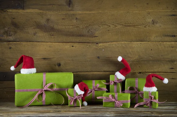 Christmas presents in apple green decorated with red santa hats