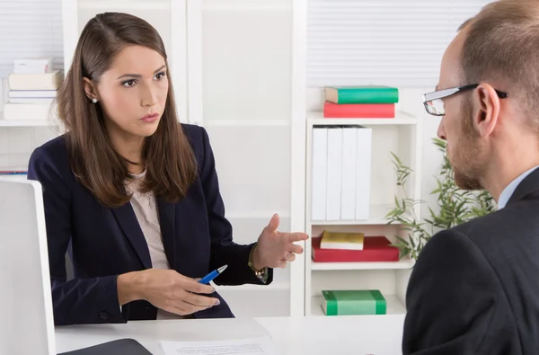 Customer and female financial agent in a discussion at desk.