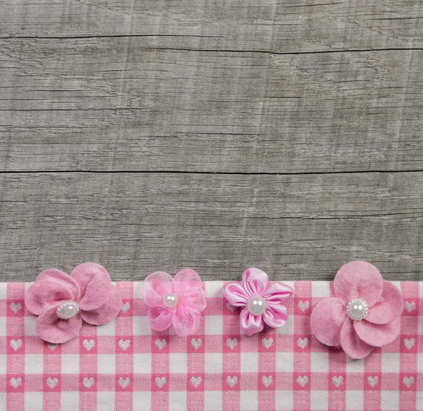 Four pink handmade flowers on wooden grey shabby chic background