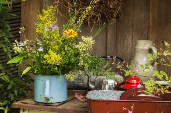 Old antique cooking pots with a bunch of flowers in the garden.