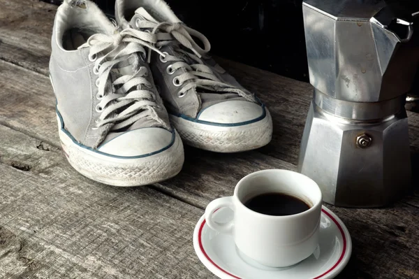 Espresso coffee, espresso maker and dirty sneakers