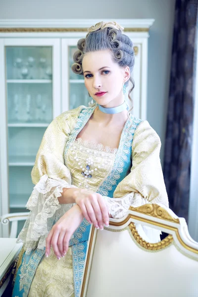 Beautiful woman in historical dress in Baroque style in the inte
