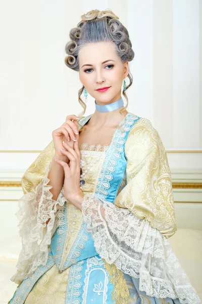 Beautiful woman in historical dress in Baroque style in the inte