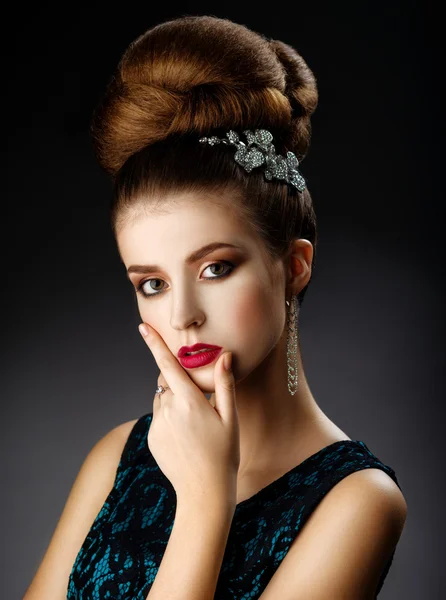 Fashion model touches face. Updo.