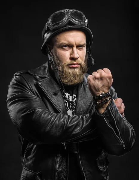 Angry Bearded Biker Man in Leather Jacket and Helmet over Black