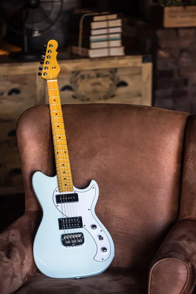 Electric Guitar Leaning Against a Couch
