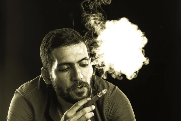 Man Smoking Cigar surrounded by Smoke