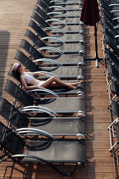 Sexy young woman relaxing on deck chair. sexy girl in bikini lyi