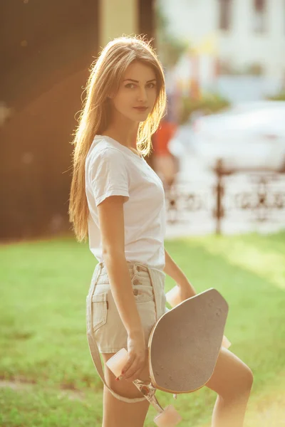 Sport fashion brunette girl in denim shorts, posing in summer wi