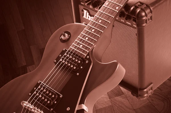 Part of electric guitar on wooden background. Old style