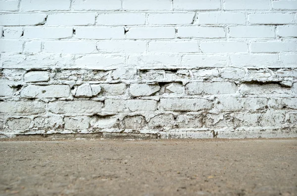 Empty grunge brick wall with ground floor