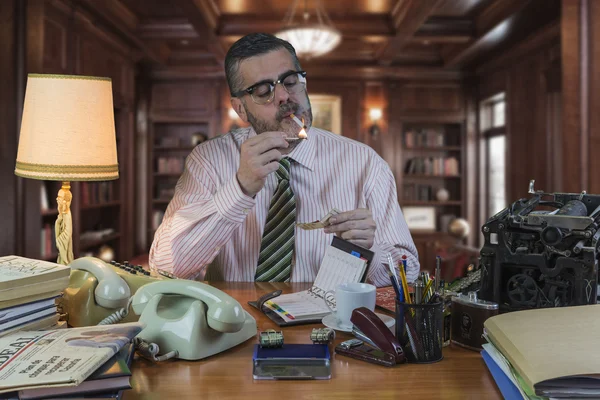 Employee with glasses Lighting a cigarette with a classic match